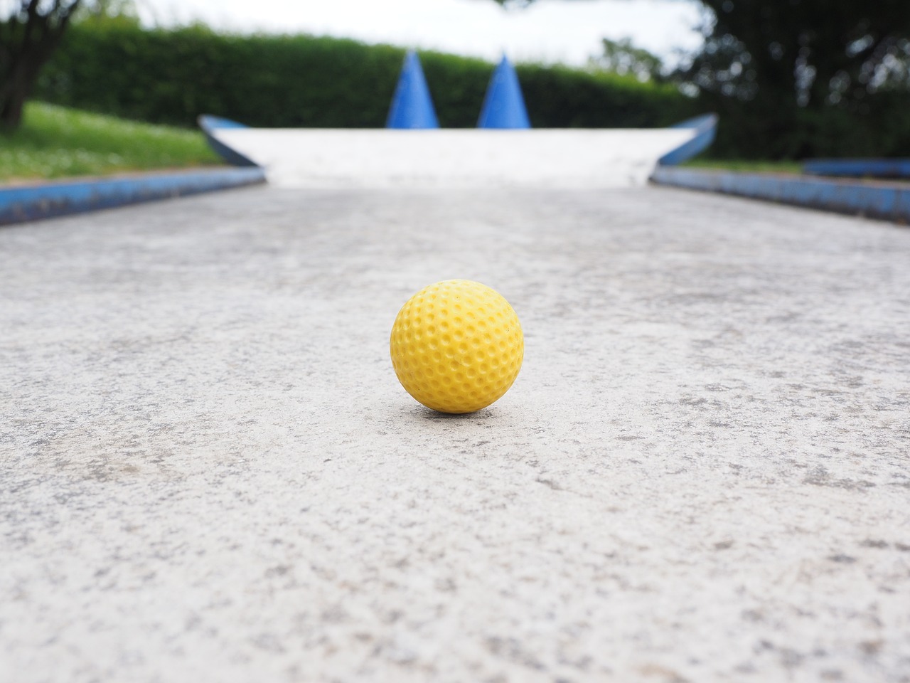 A yellow mini golf ball on the track